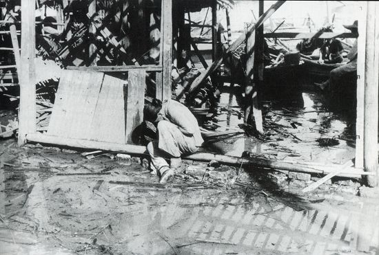 1938年7-9月間，漢口，一次日軍的空襲之后，在被毀的家園前哀傷的婦女。