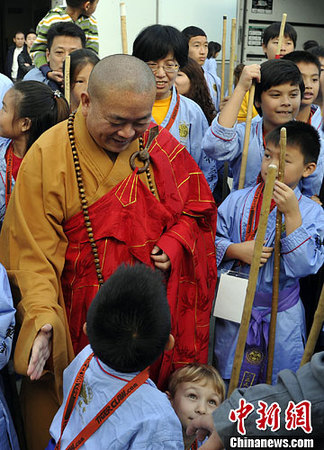 圖為少林寺釋永信方丈與參加武術(shù)交流的兒童們交談。中新社發(fā) 毛建軍 攝