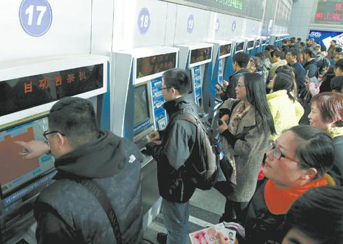 12月7日，乘客在上?；疖囌镜淖灾燮贝髲d內(nèi)購買火車票。