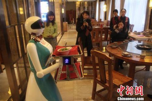 圖為機器人服務(wù)員正在為客人服務(wù)?！〈麒础z