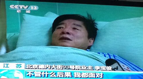 挖坑人大代表躺病床上受訪，流淚稱愿受懲罰。視頻截圖