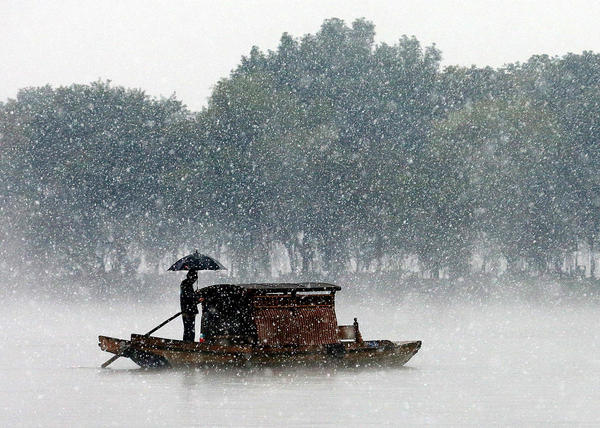 12月5日，杭州降下2015年入冬第一場雪。沒有一點(diǎn)點(diǎn)防備，杭州的初雪就洋洋灑灑地飄落了，雪越來越大，氣溫也驟降，西湖的水面上飄起層層白霧，與雪花攪在一起，如夢似幻。林云龍 視覺中國