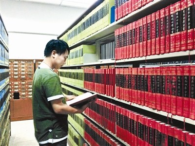 資料圖：一名古籍愛好者正在北大古籍閱覽室翻看“四庫全書”。圖片來源：北京青年報