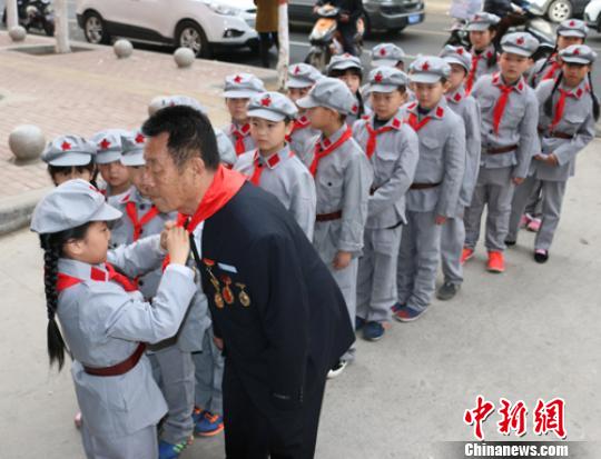 受谷殿明血雷鋒事跡的感染，雷鋒小標(biāo)兵為這位“活雷鋒”爺爺系上紅領(lǐng)巾?！」鶊@ 攝