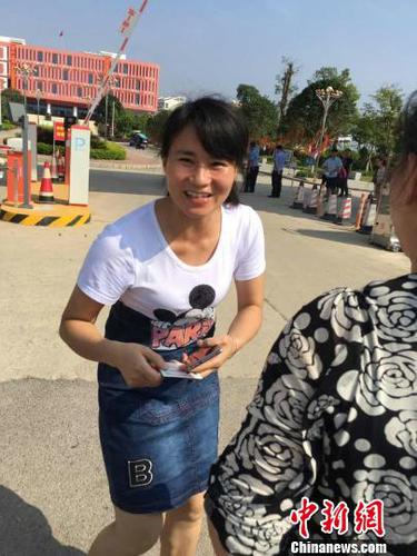 王女士將兒子身份證送到考點(diǎn)門口交給送考老師。　姚振男　攝