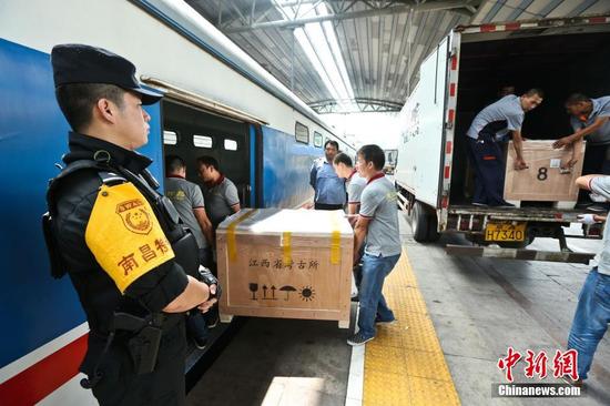 圖為6月29日，在北京站，文物保護人員將?；韬钗奈锇徇\上列車。 張學東 攝