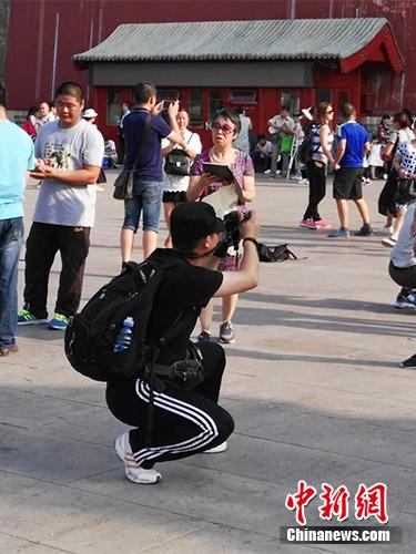 游客在故宮北門外拍照。中新網(wǎng)記者 宋宇晟 攝