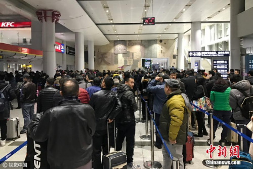 12月20日清晨，北京，受大霧天氣影響，首都機場多個航班出現(xiàn)延誤、取消等情況，退票改簽的乘客在首都機場航站樓前排起了長隊。圖片來源：視覺中國