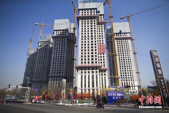 資料圖 民眾從一在建商業(yè)樓盤前經(jīng)過(guò)。<a target='_blank' href='http://www.chinanews.com/'>中新社</a>記者 張?jiān)?攝