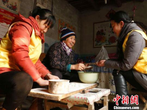 資料圖：除夕，巨鹿縣居家養(yǎng)老服務(wù)中心工作人員王勝晨、陳云彩和失獨老人張會群一起包餃子?！⊥醣麖?攝