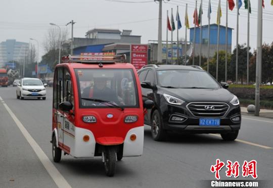 一位老者駕駛電動(dòng)三輪車行駛在省道103線公路眉山段?！⒅铱?攝