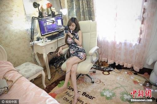 圖為27歲的劉洋在自己的臥室里做直播，她2015年開始，從一名就職于化工企業(yè)的工科女搖身一變成為職業(yè)主播，月收入也是此前工作的五倍之多。 游思行 攝 圖片來源：視覺中國