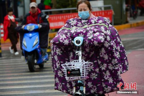 10月9日，內(nèi)蒙古多地大幅降溫，在呼和浩特街頭，騎電動車的行人穿上“棉衣”出行。 <a target='_blank' href='http://www.chinanews.com/'>中新社</a>記者 劉文華 攝