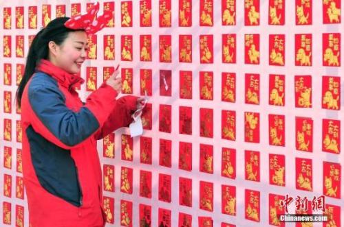 資料圖：2018年2月16日，大年初一，游客來(lái)到天津方特歡樂(lè)世界紅包墻前搶包紅。<a target='_blank' href='http://www.chinanews.com/'>中新社</a>記者 佟郁 攝