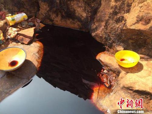 從石崖縫隙里滲出的黑褐色不明液體，從顏色看如醬油狀。　劉鵬 攝