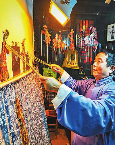 山東臺(tái)兒莊古城非遺文化展示區(qū)，現(xiàn)年60歲的國家級(jí)非物質(zhì)文化遺產(chǎn)魯南皮影戲傳承人陳守科正在向游客表演皮影戲，讓游客們感受傳統(tǒng)文化的魅力。高啟民攝