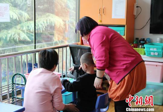 走進濟南安安特殊兒童康復中心，老師和家長正帶著自閉癥孩子玩游戲?！≮w曉 攝