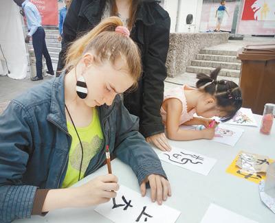 中國僑網(wǎng)6月10日，為期4天的第三屆比利時(shí)列日省“中國城會(huì)”活動(dòng)落下帷幕。圖為列日大學(xué)的學(xué)生在活動(dòng)現(xiàn)場(chǎng)學(xué)習(xí)書法。 本報(bào)記者 任 彥攝 