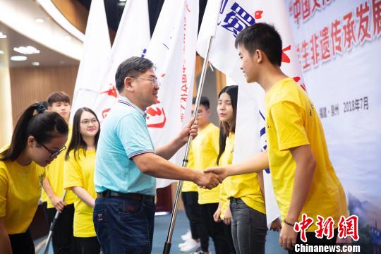 華僑大學(xué)校長(zhǎng)助理張?jiān)撇?018年“中華文化之旅“6個(gè)研習(xí)營(yíng)的學(xué)生代表授旗。伊凡 攝