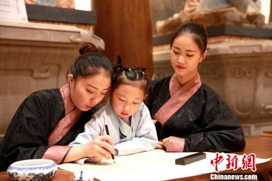 圖為志愿者在開(kāi)幕式會(huì)場(chǎng)展示中國(guó)書(shū)法?！×籂?攝