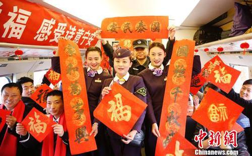 列車(chē)員和乘客一起展示春聯(lián)和福字。　張婭子　攝