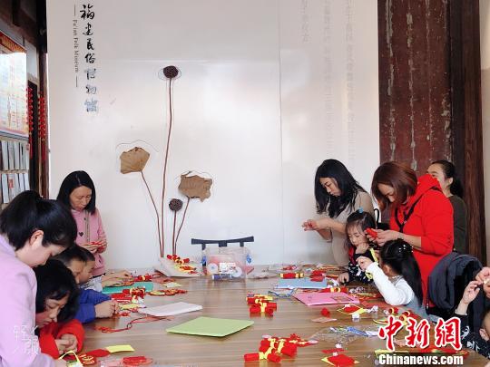家長(zhǎng)帶著小朋友參與趣味手工體驗(yàn)活動(dòng)?！∪~秋云 攝