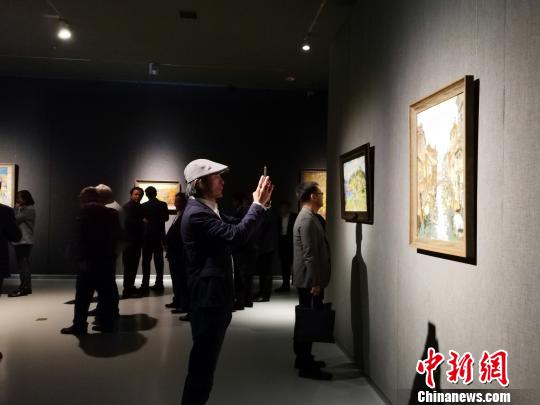 圖為，在“印象山東——俄羅斯油畫家寫生作品展”上，觀眾在喜歡的作品前駐足觀賞、拍照?！O宏瑗 攝