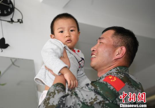 卞龍抱起兒子?！钤傩?攝