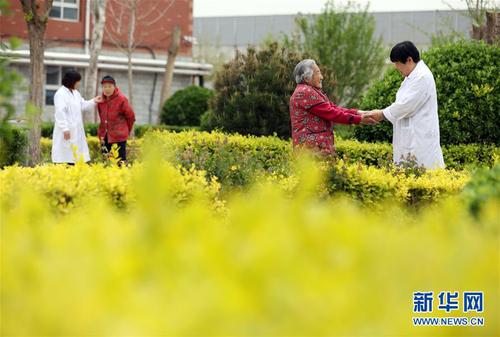 5月5日，在河北省衡水市桃城區(qū)一家養(yǎng)老康復(fù)醫(yī)療中心，護(hù)工在陪老人散步。新華社記者 牟宇 攝