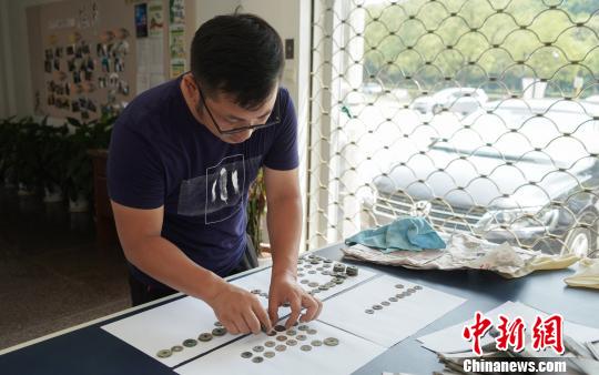 工作人員在研究古錢幣“身份”?！盍⒊?攝