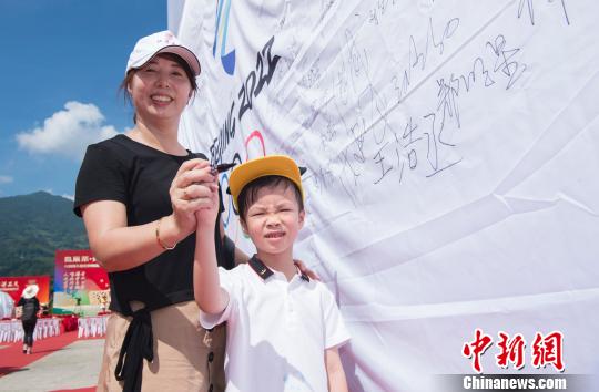 圖為坦洋村民在助威冬奧的條幅上簽字?！∠牟ü?攝