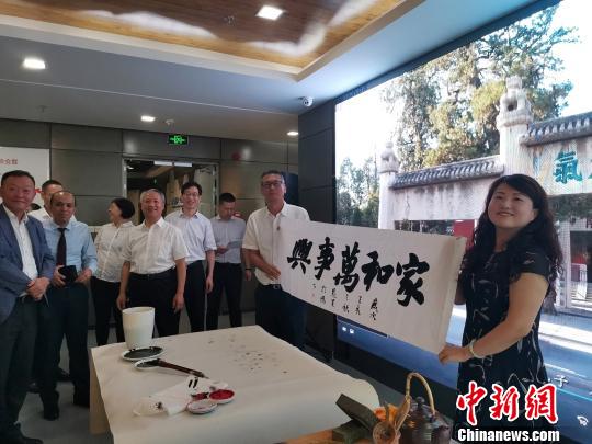 圖為，慶祝新中國成立70周年外國專家座談會暨駐濟外國人才中秋節(jié)沙龍觀上，外國專家展示獲贈書法作品?！O宏瑗 攝