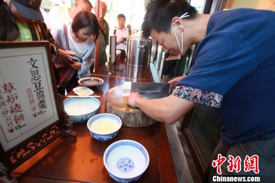 圖為揚州廚師為游客表演淮揚菜經(jīng)典“文思豆腐”的切制?！∶系慢?攝