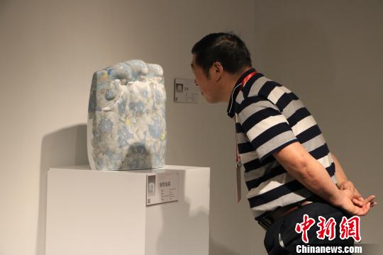 9月20日，第十三屆全國(guó)美術(shù)作品展覽陶藝作品展作品吸引觀(guān)者駐足觀(guān)賞。　李韻涵 攝