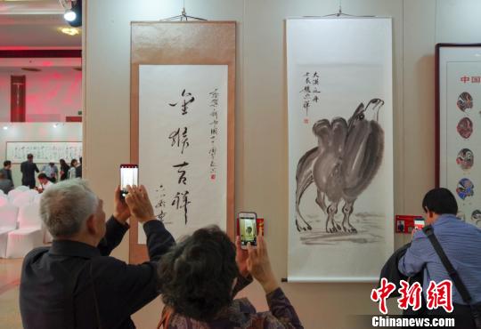 9日，觀眾在“慶祝中華人民共和國(guó)成立70周年——影視藝術(shù)家優(yōu)秀書畫作品展”上參觀六小齡童的書法作品《金猴吉祥》和趙忠祥的畫作《大漠之舟》?！?lt;a target='_blank' href='http://www.chinanews.com/'>中新社</a>記者 賈天勇 攝