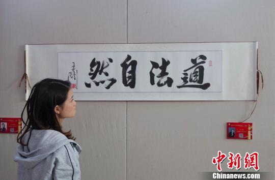 9日，觀眾在“慶祝中華人民共和國(guó)成立70周年——影視藝術(shù)家優(yōu)秀書畫作品展”上參觀王剛的書法作品《道法自然》?！?lt;a target='_blank' href='http://www.chinanews.com/'>中新社</a>記者 賈天勇 攝