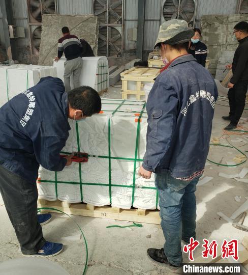 工人們在對驗收后的《埃塞贊歌》浮雕墻分包裝箱。　薄麗麗 攝