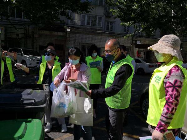 委員們幫助居民對垃圾進(jìn)行分類投放