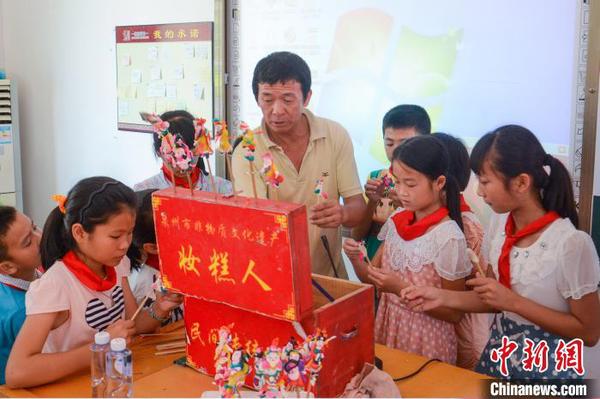 張明鐵到學(xué)校為孩子們教授“妝糕人”制作技藝?！埶囆?攝