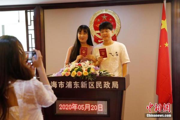 資料圖：兩位市民手持結(jié)婚證合影留念。 殷立勤 攝